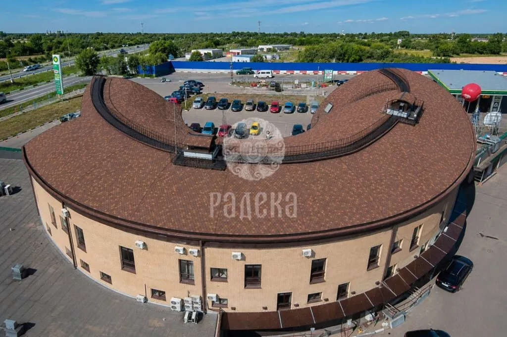 Общий вид офисного центра «Колизей» с подковообразной кровлей из гибкой черепицы CertainTeed Highland Slate.