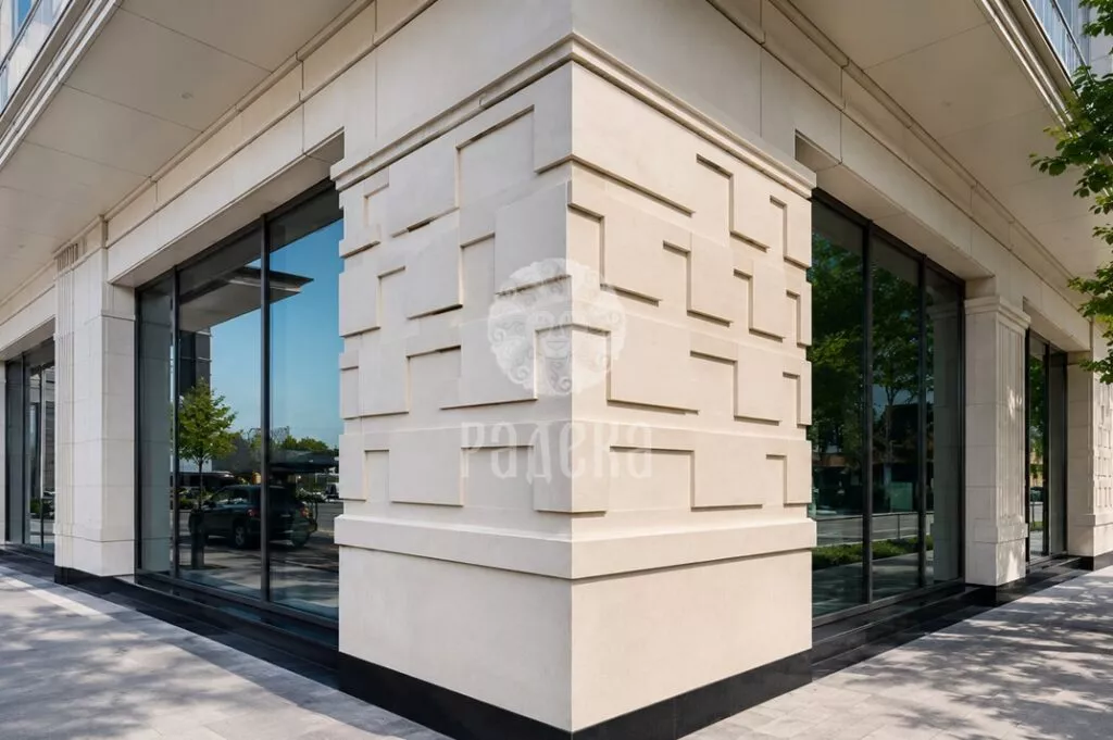 Geometric relief at the corner of the stone facade between panoramic windows.