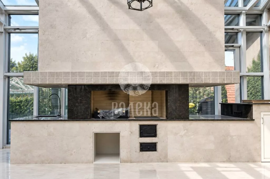 Front view of the barbecue with light stone cladding, a dark countertop and a granite firebox surround.