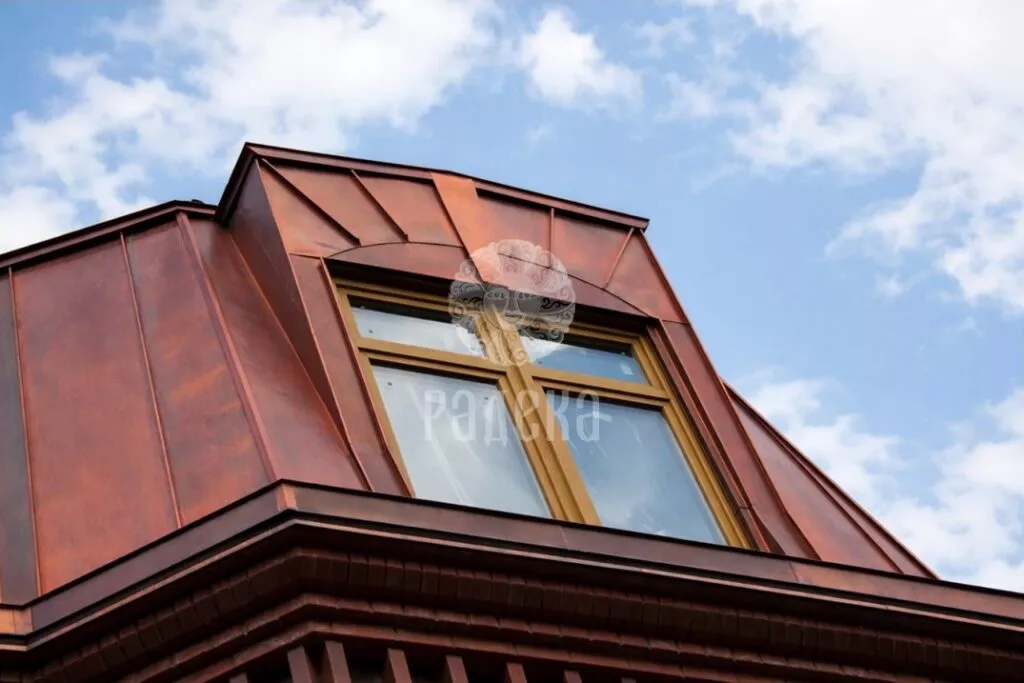 Large dormer window in the copper roof, shot from below against the sky