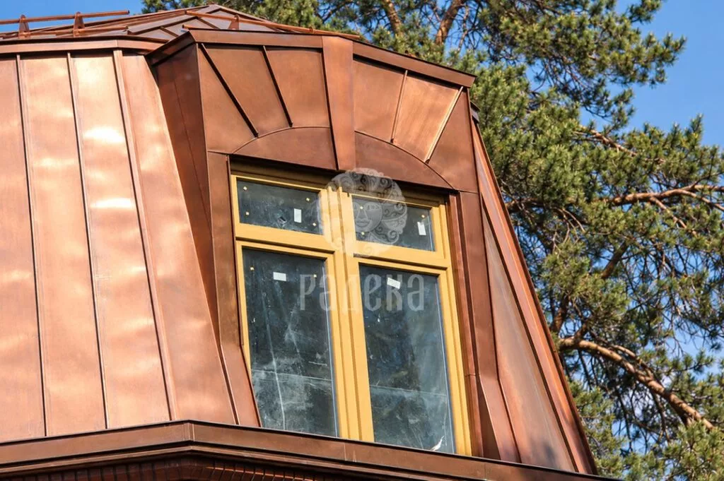 Dormer window with a fan-shaped arrangement of copper panels above the opening
