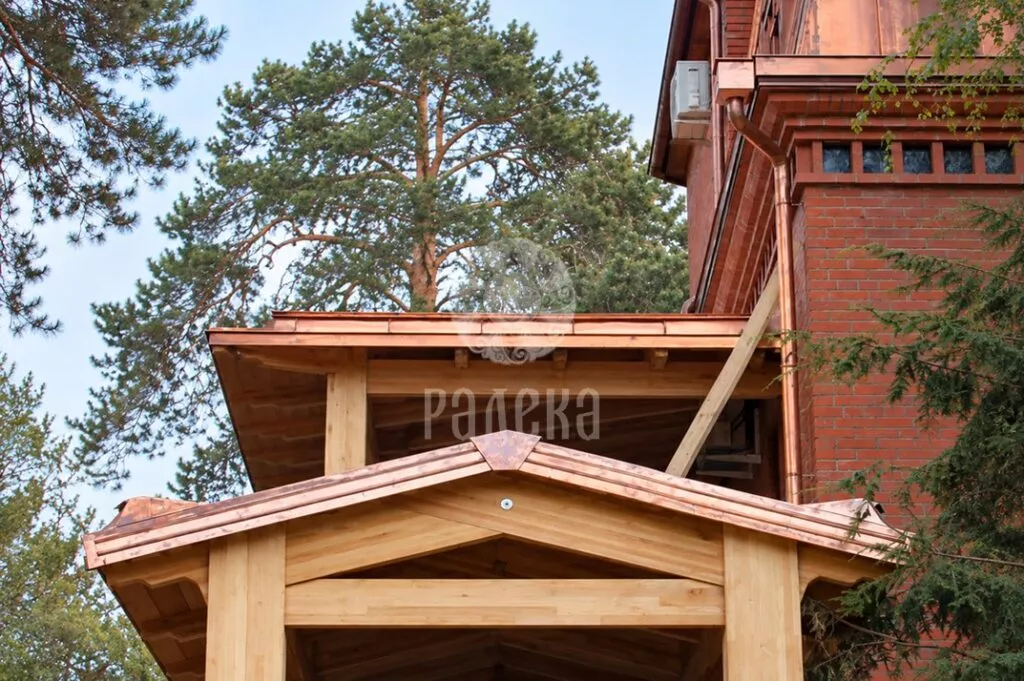 Timber-framed canopies with copper roofing beside a brick house