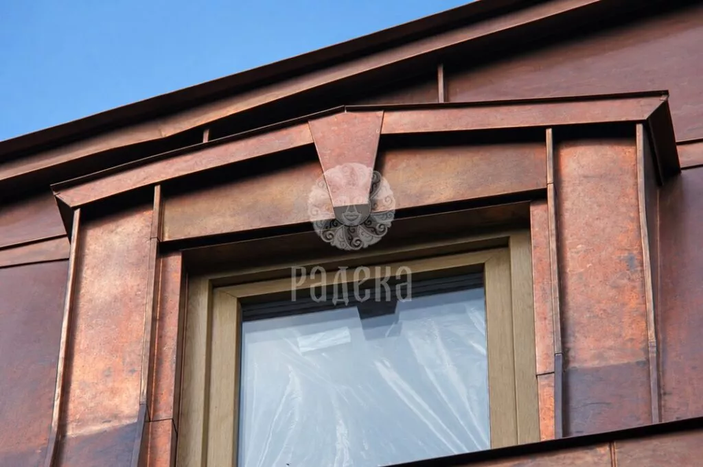 Copper surround to a dormer window with a central trapezoidal cover plate
