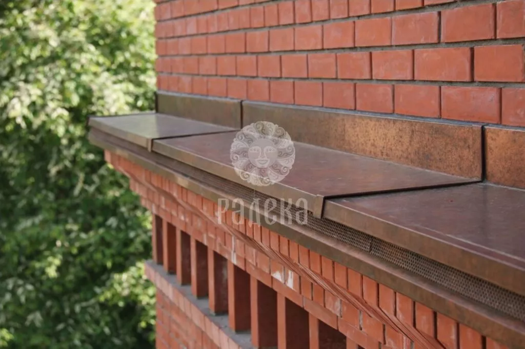Copper covering of the brick cornice adjacent to the wall