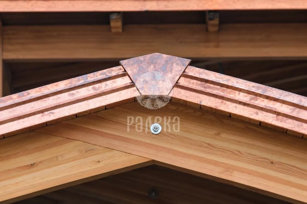 Central joint between copper trim sections above the timber canopy gable