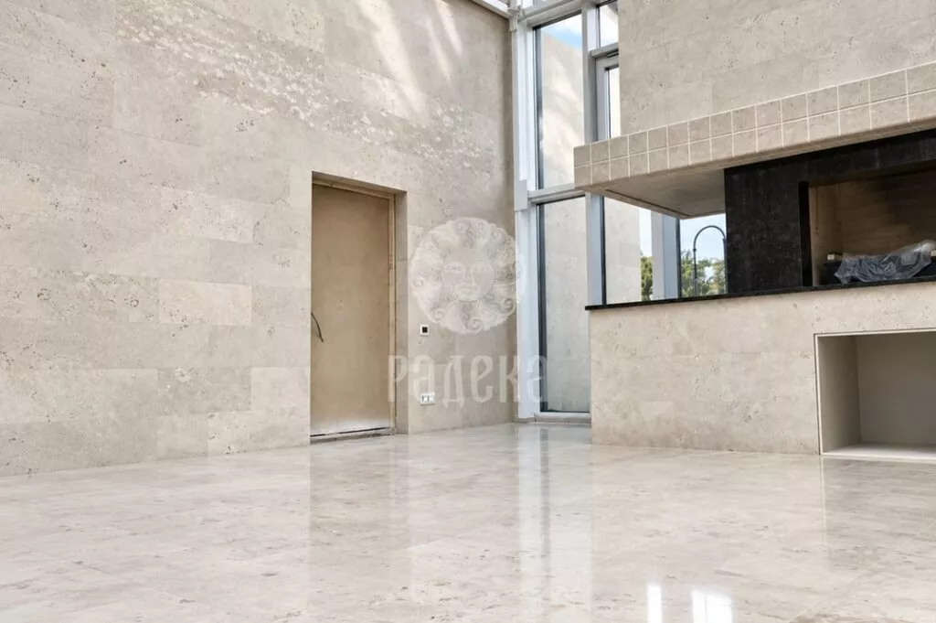 Dolomite-clad wall with a door opening and polished stone floor next to the barbecue