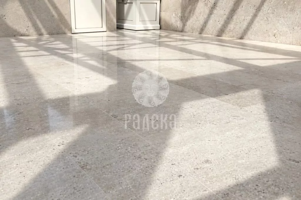 Polished light dolomite slabs reflecting windows and shadows from the glass roof