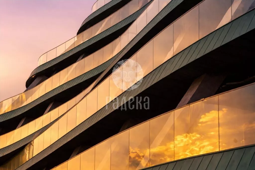 Sunset reflected in the glass railings of the Reef Residence balconies with copper cladding.
