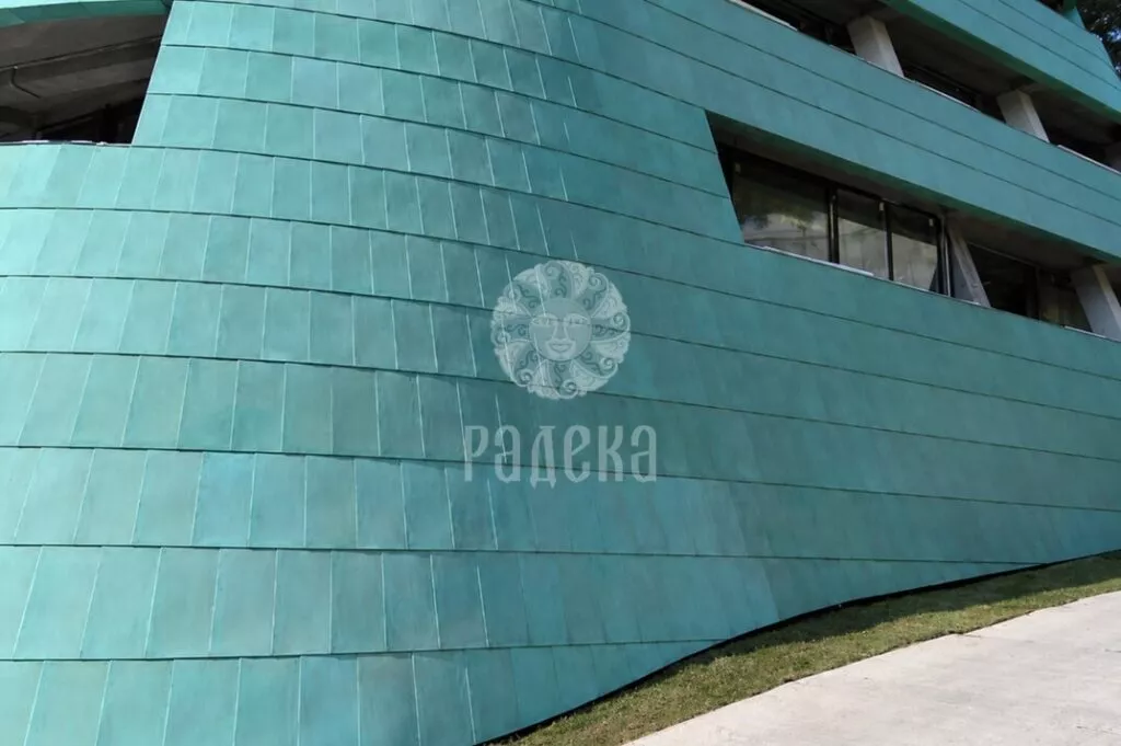 Curvilinear lower part of the Reef Residence facade with patinated copper cladding.