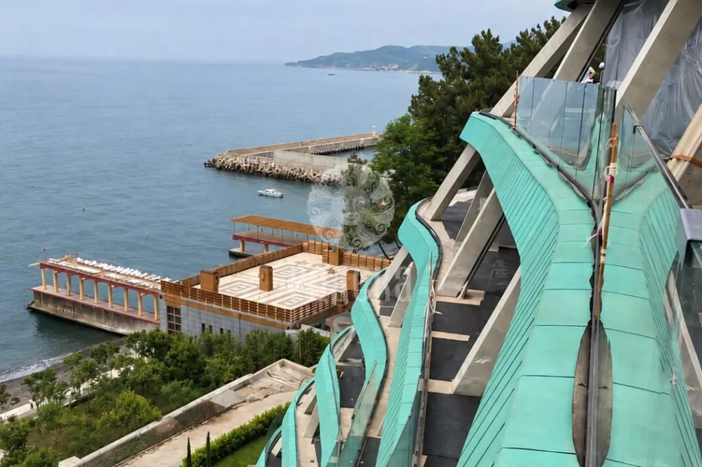 Curved balconies of Reef Residence with copper cladding and a view of the Black Sea.