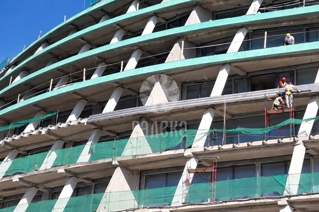 Installers fitting patinated copper cladding to the horizontal facade bands of Reef Residence.